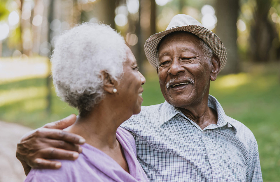 Smiling elderly couple enjoying time together in a sunny park.