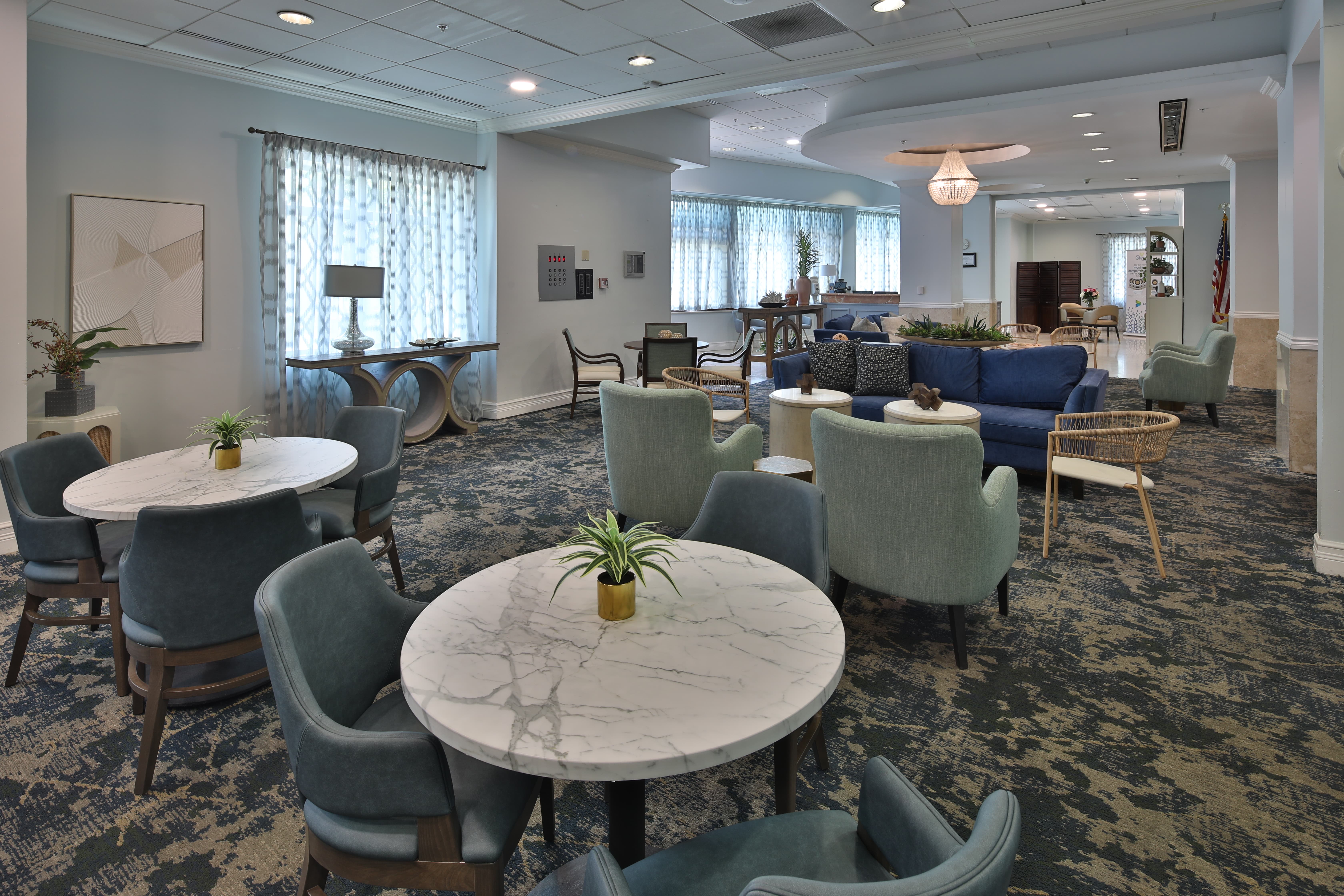 Senior Living Community Common Area Modern common area in a senior living community with chairs, sofa, table, and artworks on the wall.