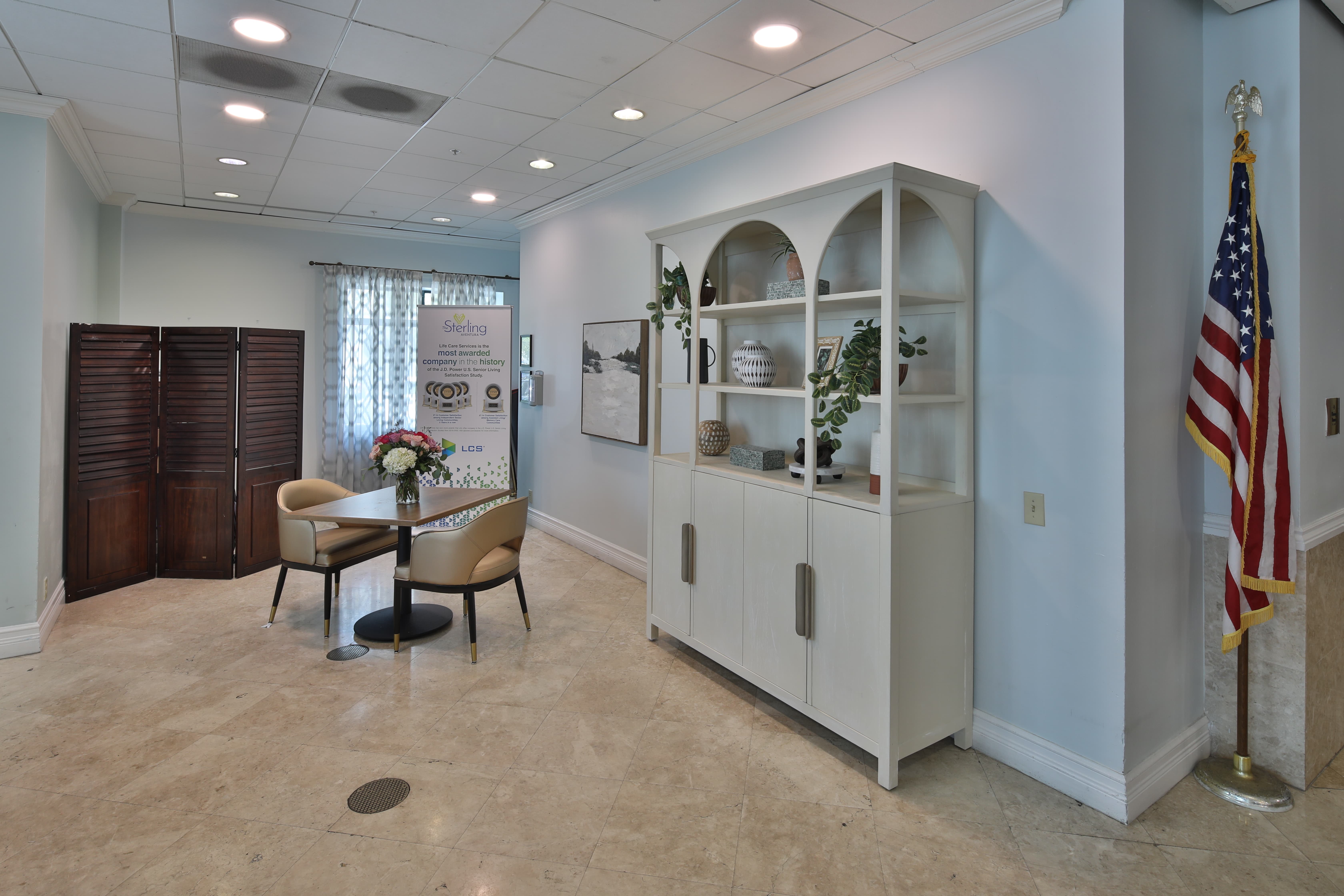 Senior Living Community Welcoming Area Welcoming area in a senior living community with seating, bookshelf, and American flag.